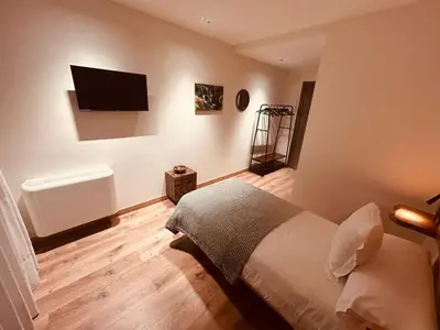 a bedroom with a bed and a television on the wall at A Reigada Hotel Restaurante in Grandas de Salime