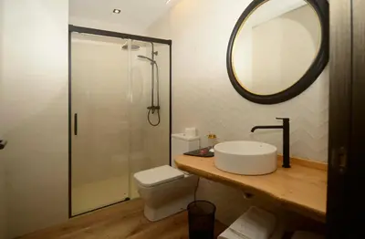 a bathroom with a sink and a shower with a mirror at A Reigada Hotel Restaurante in Grandas de Salime