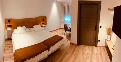 a bedroom with a large bed with a wooden headboard at A Reigada Hotel Restaurante in Grandas de Salime