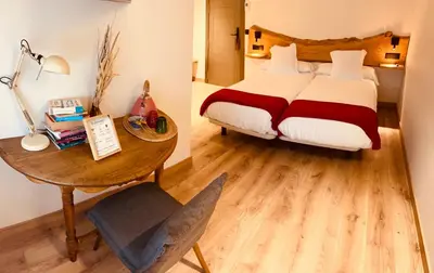 a bedroom with a bed and a table with a desk at A Reigada Hotel Restaurante in Grandas de Salime