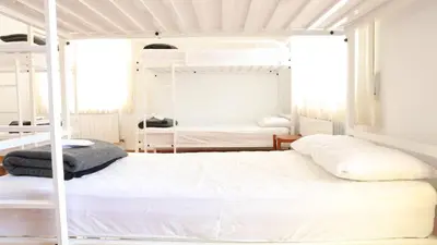 a bedroom with two bunk beds with white walls at Pensión Albergue Gonzar in Portomarin
