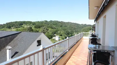 a balcony with a camera on the side of a building at Pensión Albergue Gonzar in Portomarin