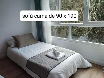 a bed in a bedroom with two windows at O Paseo, 5 estrellas. in Puentedeume