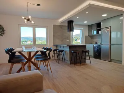 a kitchen and living room with a table and chairs at O Paseo, 5 estrellas. in Puentedeume