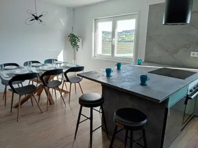 a kitchen with a counter and a table with stools at O Paseo, 5 estrellas. in Puentedeume