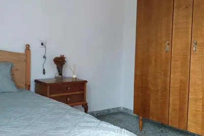 a bedroom with a bed and a wooden cabinet at Casa Cuco in Corejido