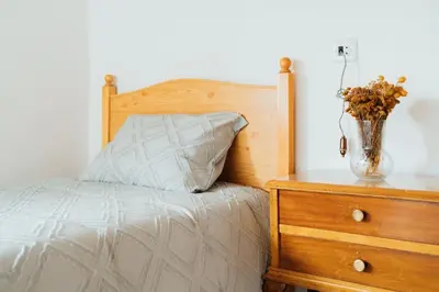 a bedroom with a bed and a vase with flowers on a dresser at Casa Cuco in Corejido