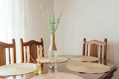 a dining room table with plates and a vase with flowers at Casa Cuco in Corejido