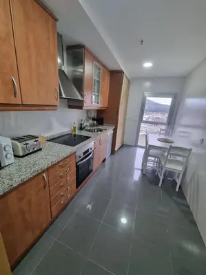 a kitchen with a sink and a table with chairs at El mirador del Rosal in Ponferrada