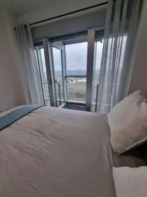 a bedroom with a bed and a large window at El mirador del Rosal in Ponferrada