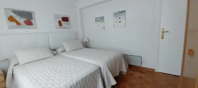 a white bedroom with a white bed in a room at Solerma in Viveiro