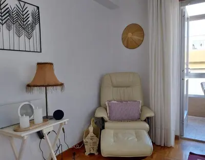 a chair in a room with a table and a lamp at Solerma in Viveiro