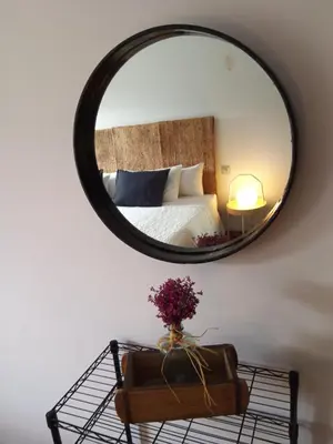 a mirror on a wall with a bed in a room at Lar A Rola El precio x una noche es para dia y medio Check in 9am Out 21pm in Sabucedo