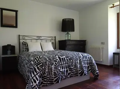 a bedroom with a black and white bed and a lamp at Lar A Rola El precio x una noche es para dia y medio Check in 9am Out 21pm in Sabucedo