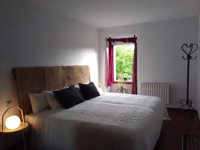 a bedroom with a large white bed with a window at Lar A Rola El precio x una noche es para dia y medio Check in 9am Out 21pm in Sabucedo