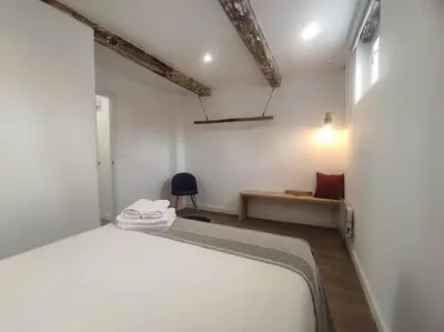 a white bedroom with a bed and a chair at Lepanto3 - Apartamento amplio y luminoso para disfrutar de Ourense in Ourense