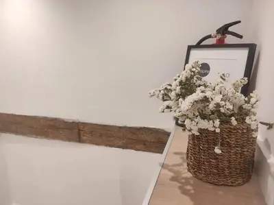 a vase filled with white flowers sitting next to a wall at Lepanto3 - Apartamento amplio y luminoso para disfrutar de Ourense in Ourense