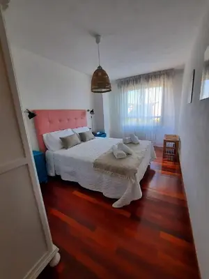 a bedroom with a large bed with a pink headboard at Apartamento En Camino - Milladoiro in Milladoiro