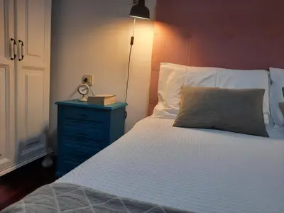 a bedroom with a bed with a blue dresser and a clock at Apartamento En Camino - Milladoiro in Milladoiro