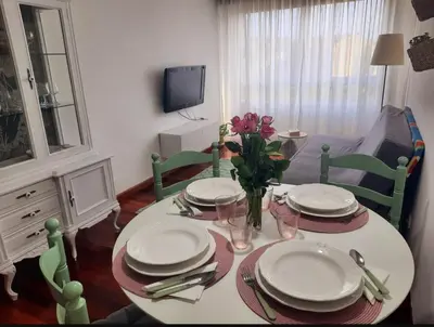 a dining room table with plates and flowers on it at Apartamento En Camino - Milladoiro in Milladoiro