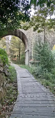 a wooden path leading to an archway in a bridge at PRECIOSO ATICO MONDARIZ in Mondariz