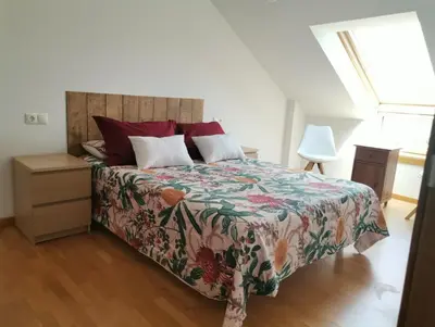 a bedroom with a large bed with a colorful bedspread at PRECIOSO ATICO MONDARIZ in Mondariz