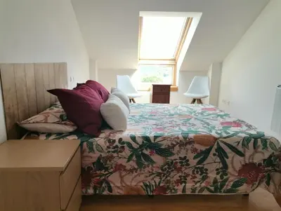 a bedroom with a bed with a floral bedspread at PRECIOSO ATICO MONDARIZ in Mondariz