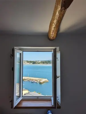 a window with a view of a body of water at Casa Buenos Aires in Ribadeo