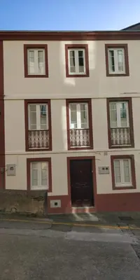 a large building with windows and a door at Casa Buenos Aires in Ribadeo