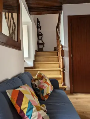 a living room with a blue couch and stairs at Casa Buenos Aires in Ribadeo