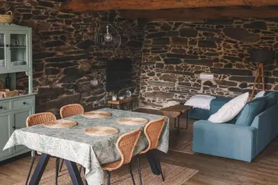 a dining room with a table and a stone wall at Casa Amencer in Francos