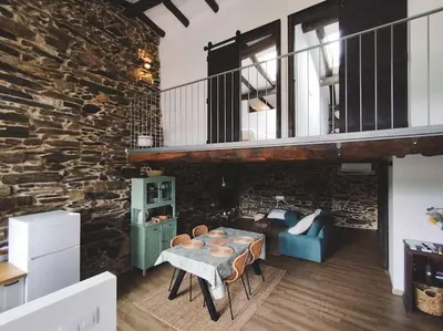 a living room with a table and a stone wall at Casa Amencer in Francos