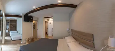 a bedroom with a large bed with a wall at NOARU Apartamentos Deluxe in Ares