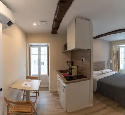 a small room with a bed and a kitchen and a table at NOARU Apartamentos Deluxe in Ares