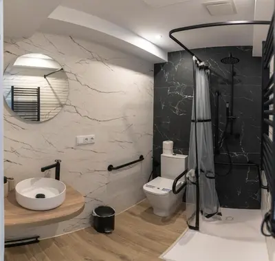 a bathroom with a shower and a toilet and a sink at NOARU Apartamentos Deluxe in Ares