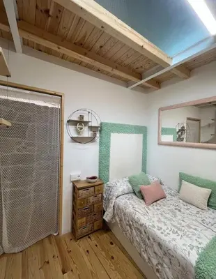 a bedroom with a bed and a mirror on the wall at O Capricho in Requeixo