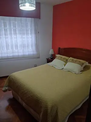 a bedroom with a bed and a window and a chandelier at Pontedeume cerca del mar y la naturaleza in Puentedeume