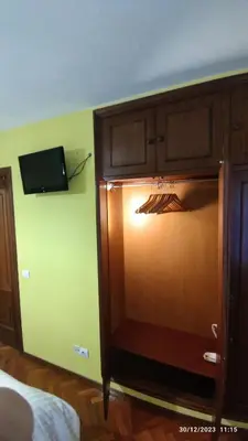 a room with a television and a wooden cabinet at Pontedeume cerca del mar y la naturaleza in Puentedeume