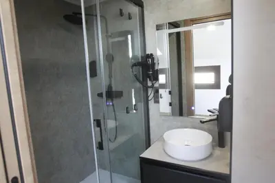 a bathroom with a glass shower and a sink at Tierra de Lemos- Apartamentos Turísticos in Monforte de Lemos