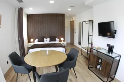 a hotel room with a bed and a table and chairs at Tierra de Lemos- Apartamentos Turísticos in Monforte de Lemos