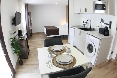 a small apartment with a dining table and a kitchen at Tierra de Lemos- Apartamentos Turísticos in Monforte de Lemos