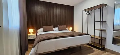 a bedroom with a bed and a black wall at Tierra de Lemos- Apartamentos Turísticos in Monforte de Lemos