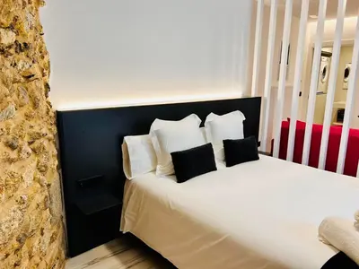 a bedroom with a bed with black and white pillows at APARTAMENTOS NADA Ó NORTE Centro in Viveiro