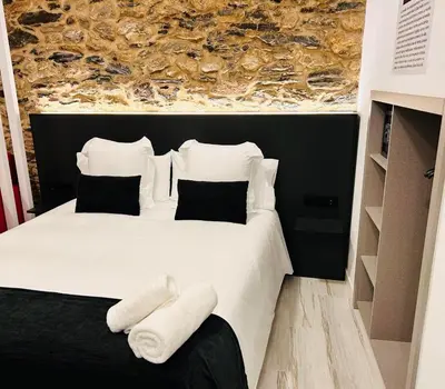 a bedroom with a white bed with two pillows at APARTAMENTOS NADA Ó NORTE Centro in Viveiro