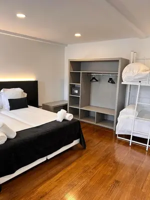 a bedroom with a bed and two bunk beds at APARTAMENTOS NADA Ó NORTE Centro in Viveiro