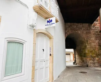 a white door with a sign on the side of a building at APARTAMENTOS NADA Ó NORTE Centro in Viveiro