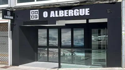 a black building with a sign that reads o elegance at O Albergue de Fene in Fene