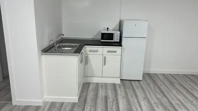 a kitchen with a white refrigerator and a microwave at O Albergue de Fene in Fene