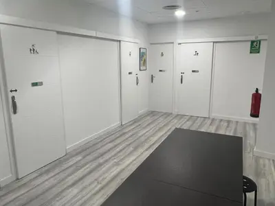 a room with white doors and a black table at O Albergue de Fene in Fene