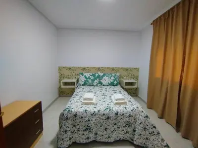 a bedroom with a bed with a floral bedspread at MARSÁN in Arzúa